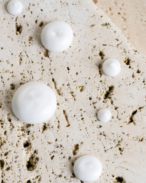White spherical objects on a textured beige surface