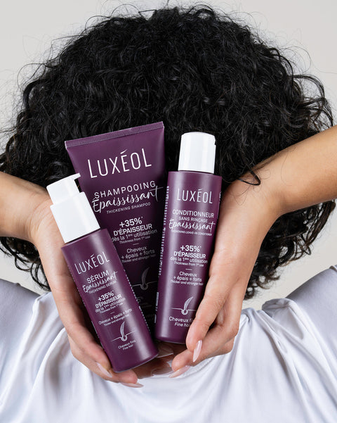 Persona, kas tur Luxéol matu kopšanas produktus ar cirtainiem matiem